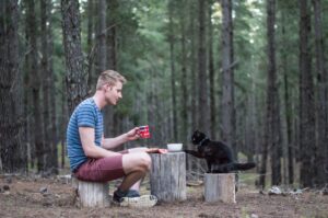 mężczyzna z kotem w lesie