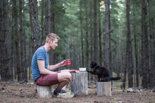 mężczyzna z kotem w lesie