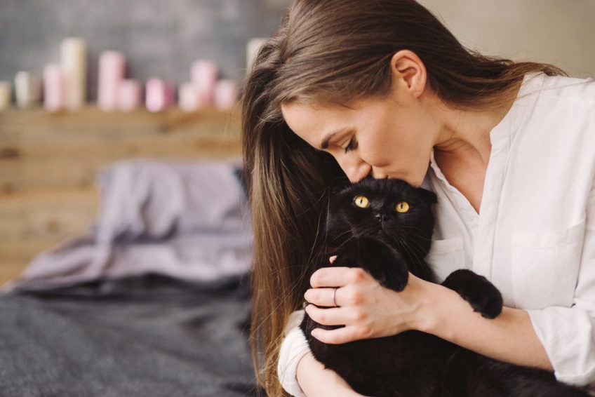 pani całuje czarnego kota