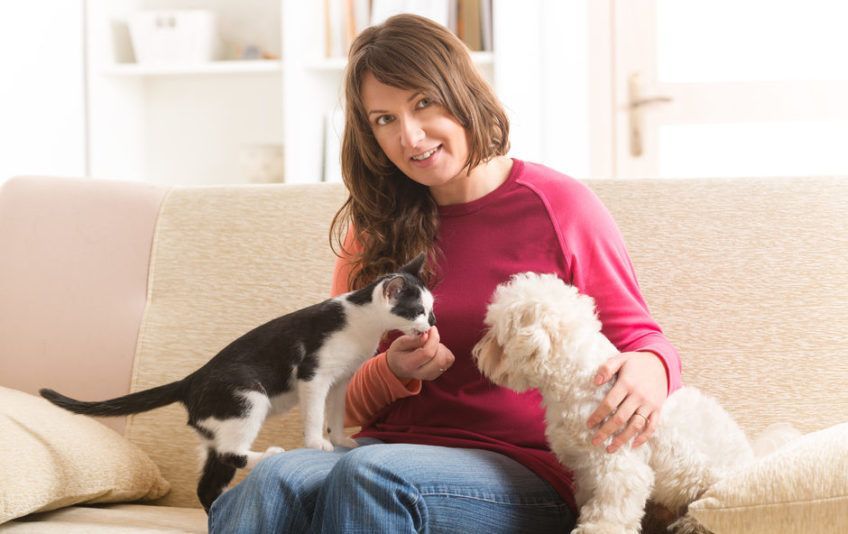 Pani z kotem i psem na kanapie